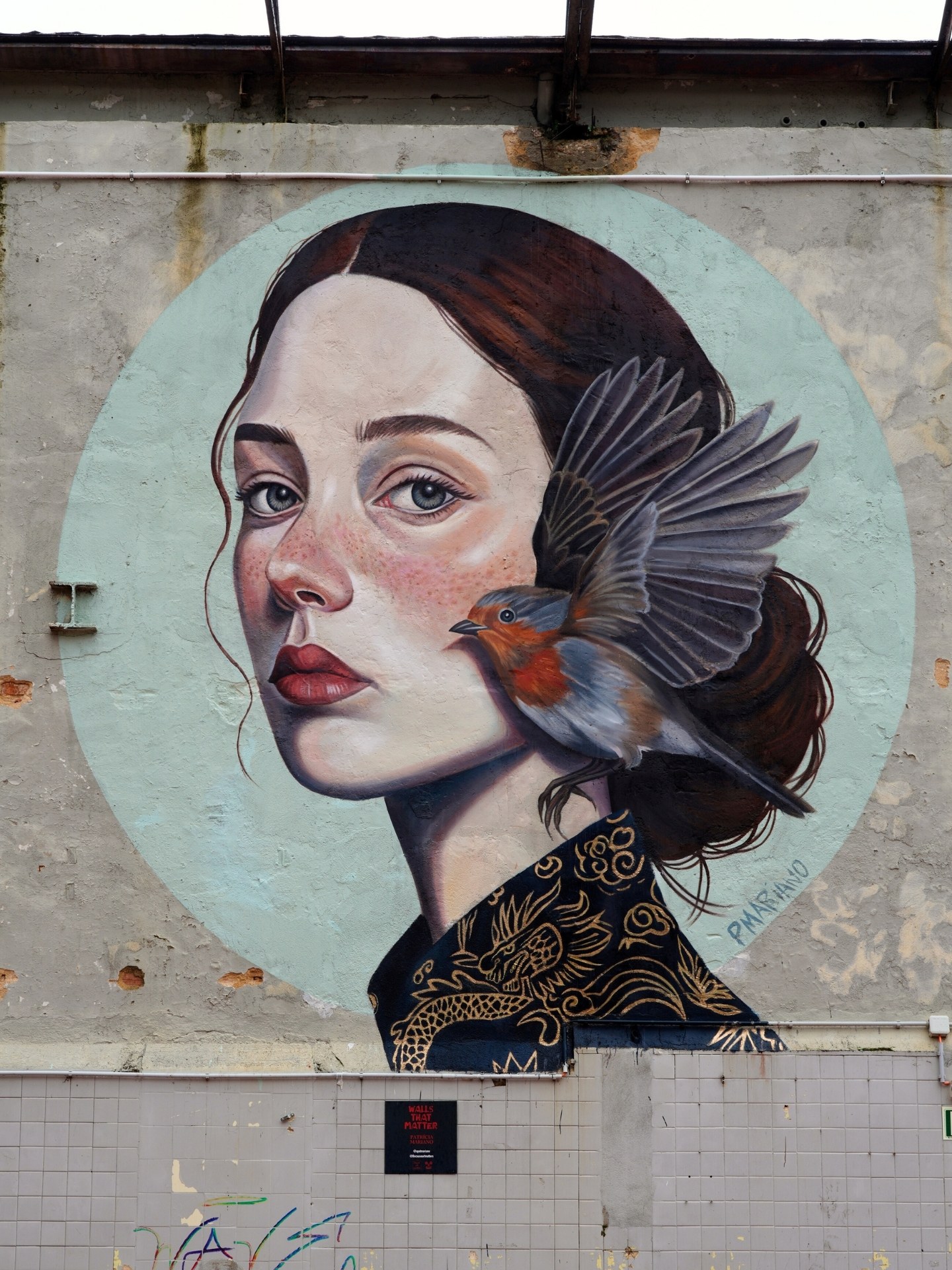 The completed "The Robin’s Whisper" contemporary portrait and bird mural by Patrícia Mariano for the Walls That Matter project, curated and produced by Because Art Matters gallery in Marvila, Lisbon.