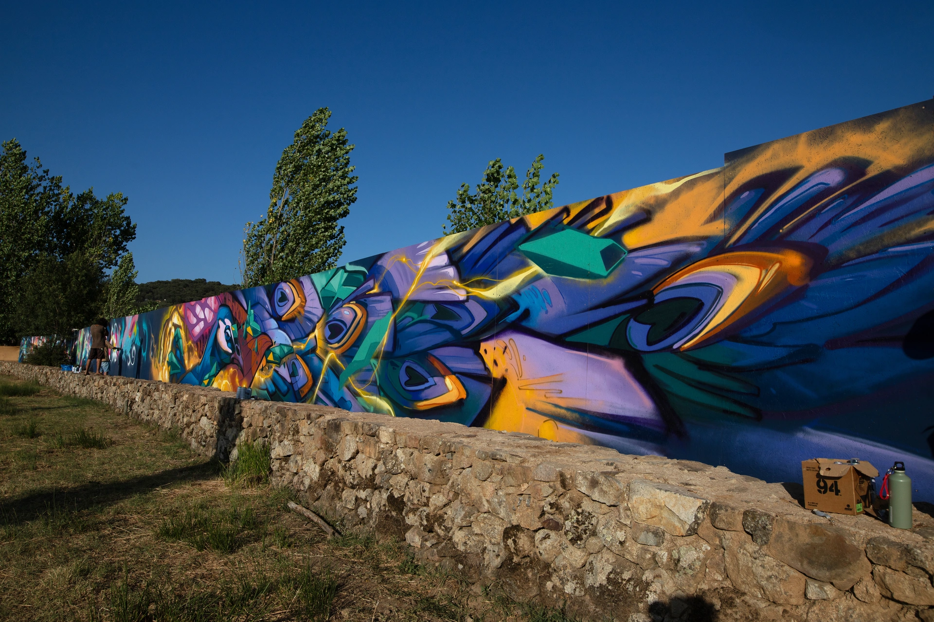 Large-scale street art mural by Carlos Breakone, created live during the Because Art Matters collaboration at Boom Festival 2023