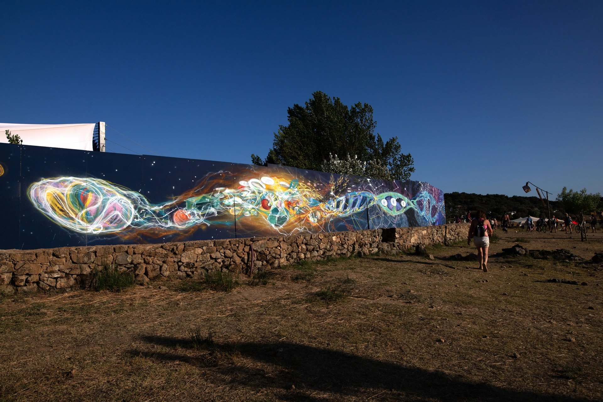 Large-scale psychedelic art mural by RAM, created live during the Because Art Matters collaboration at Boom Festival 2023