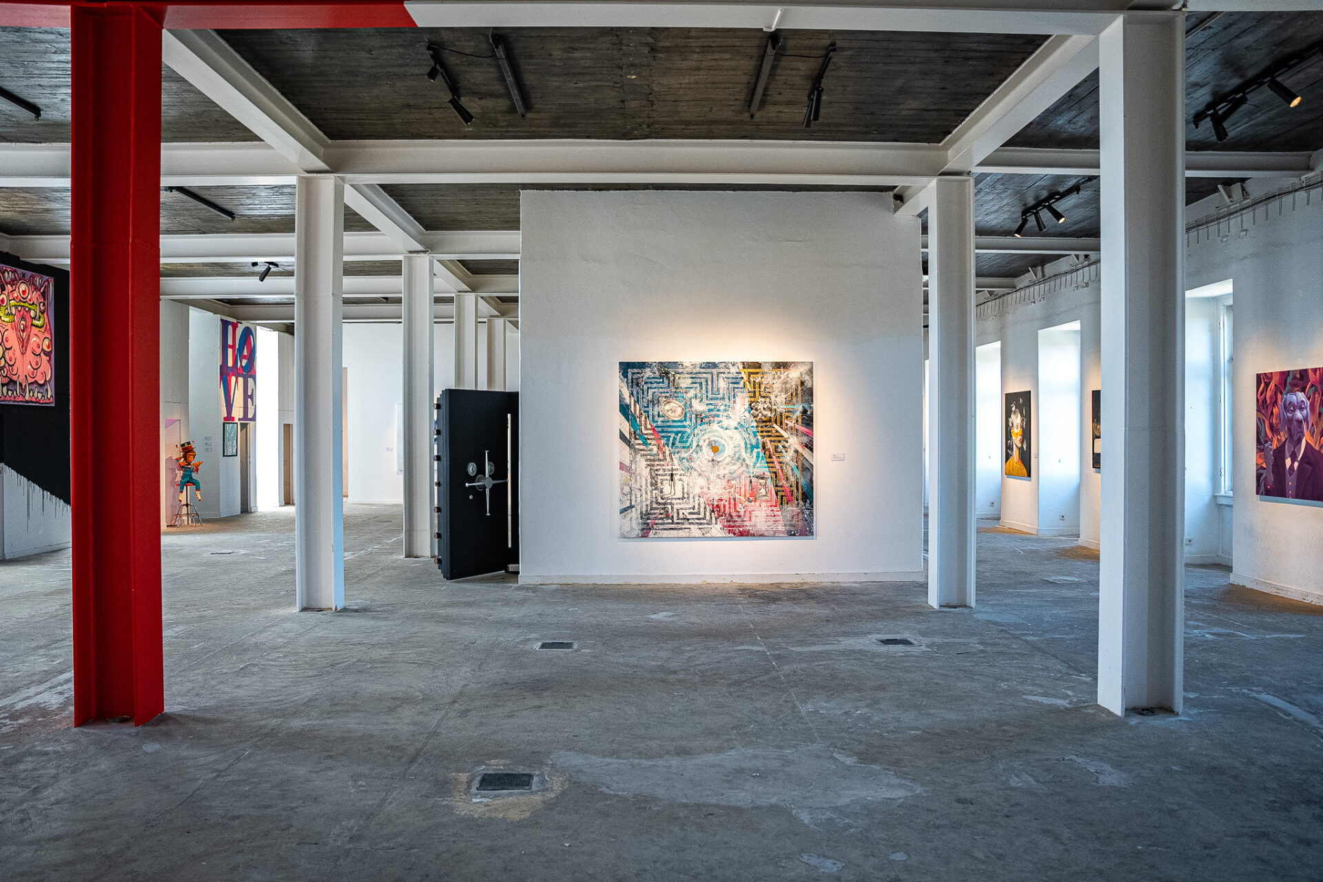 Installation view of the CHOICE collective art show artworks in Príncipe Real, Lisbon, featuring an industrial space with white pillars, curated and produced by Because Art Matters.